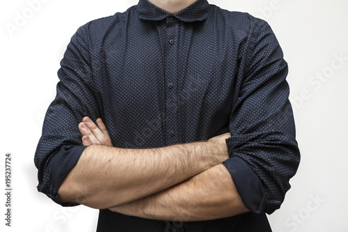 Cropped portrait of young businessman wearing formal with crossed arms on the white background. Business concept. Selective focus and shallow DOF