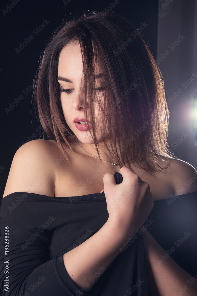 Portrait of a beautiful young sexy brunette girl on a black background. Portrait of a beautiful young sexy brunette girl on a black background.