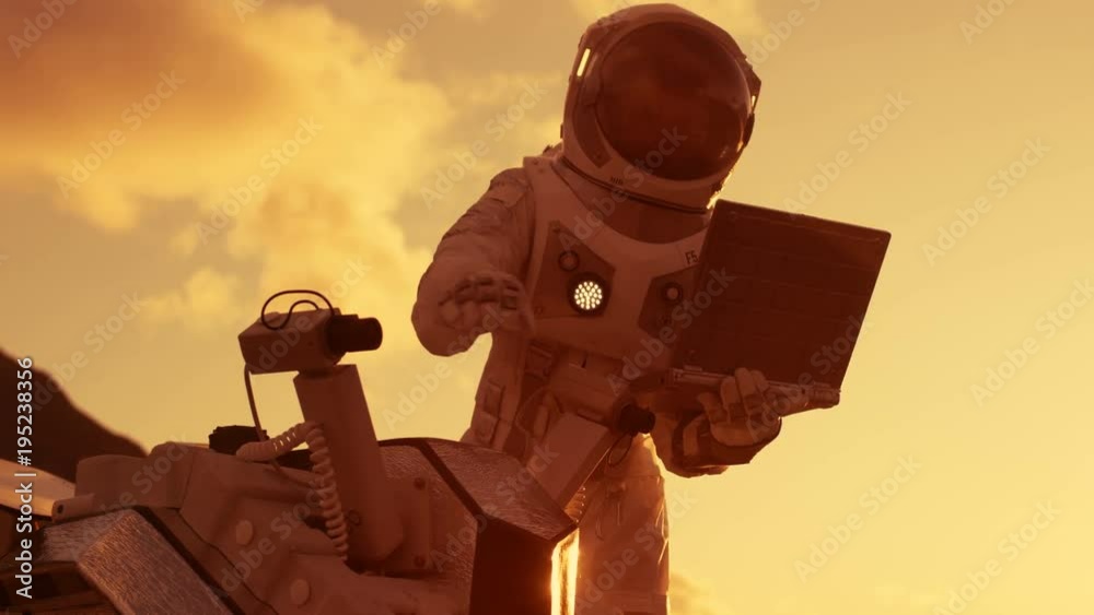Astronaut in the Space Suit Works on Laptop, Adjusting Rover For Mars further Mars Exploration.Space Exploration Concept.First Manned Mission on Red Planet. Shot on RED EPIC-W 8K Helium Cinema Camera.
