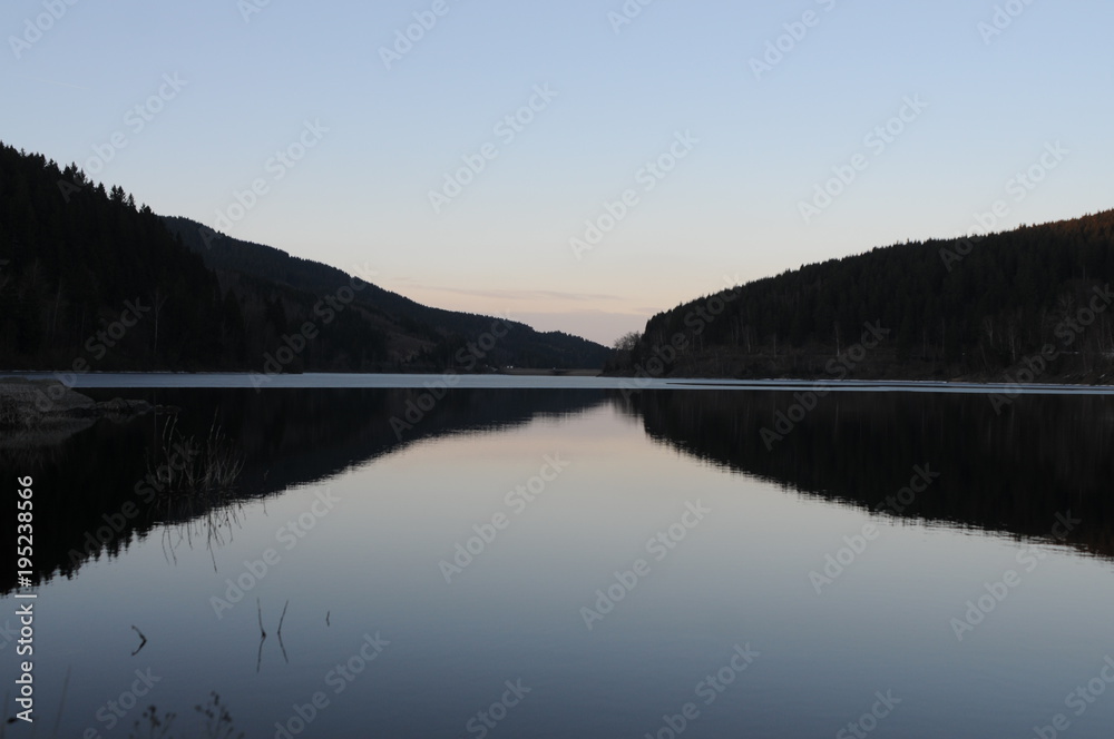 Beautiful twilight reflection in a mountain lake panorama, Oker dam in National Park Harz in Northern Germany