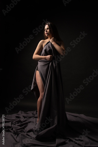 Portrait of a beautiful young sexy brunette girl on a black background.