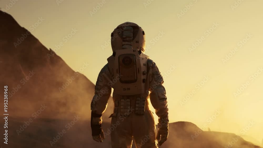 Following Shot of Astronaut Confidently Walking on Mars. Red Planet Covered in Gas and Smoke. Humans Overcoming Difficulties. Big Moment for the Human Race. Shot on RED EPIC-W 8K Helium Cinema Camera.
