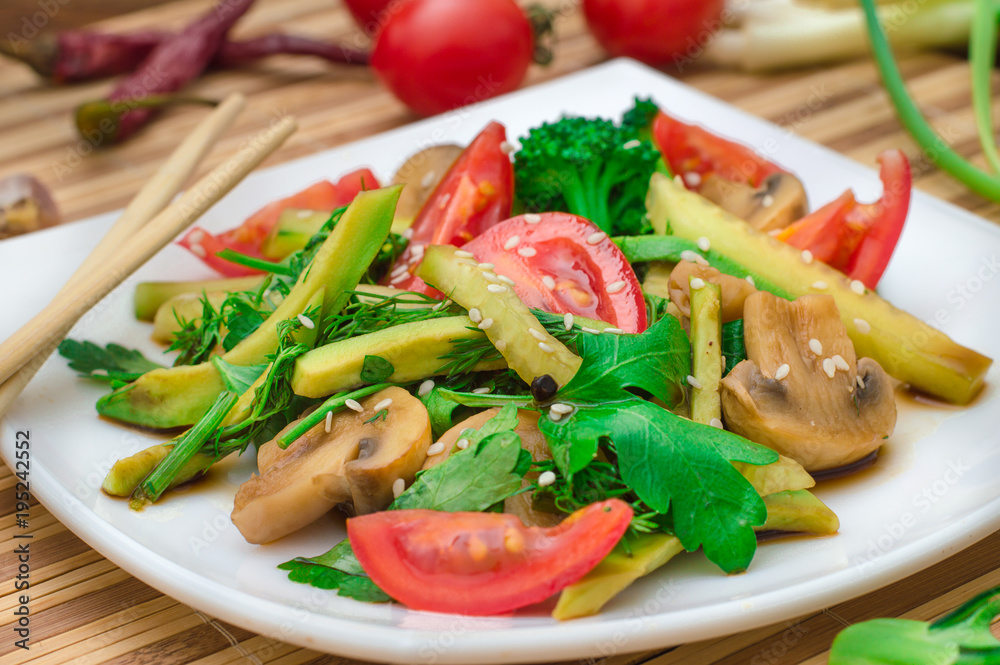 Salad with mushrooms, avocado, tomatoes and greens. Wooden rustic background. Top view Salad with mushrooms, avocado, tomatoes and greens. Wooden rustic background. Top view