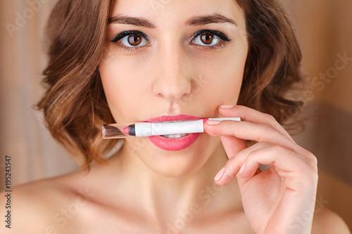 Sexy girl concept.  lipstick in female mouth  open mouth. Woman applying  new lipstick. Professional nude make-up. Attractive woman lips with  lipstick inside