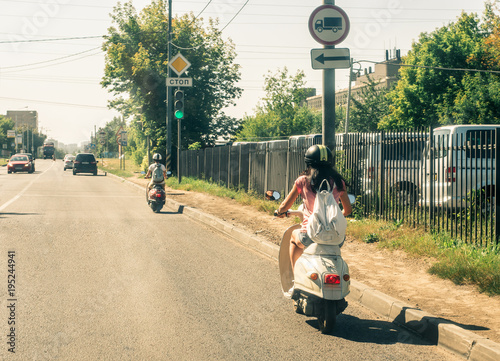 young couple on scooters at town traffic photo