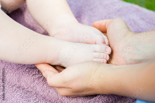 Baby feet in mother hands. Tiny newborn baby feet, concept of happy family. Fake color tone of photo..