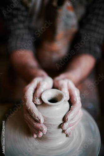 Talented  artisan working in pottery shop, making beautiful clay photo