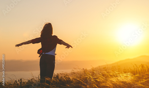 Happy woman   on sunset in nature iwith open hands