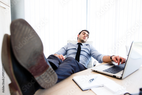 Lazy businessman put his legs on desk