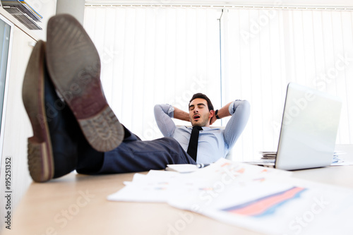 Young lazy businessman sleeps at office