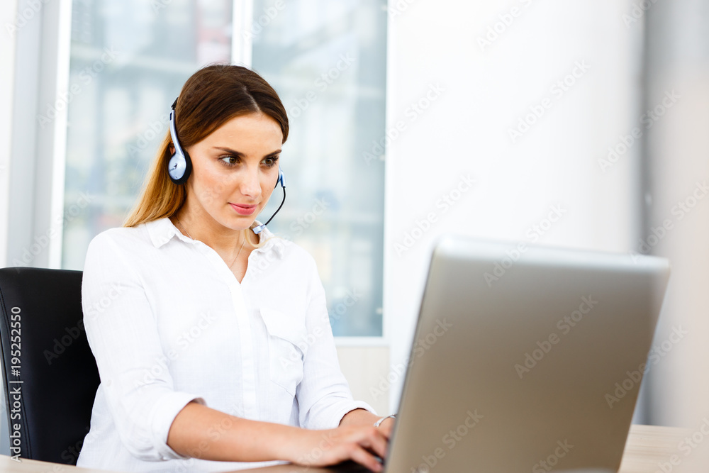 Beautiful young woman working at IT call center Beautiful young woman working at IT call center