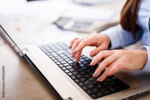 Young female IT engineer typing on laptop