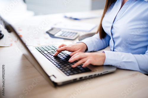 Young female IT typing on laptop