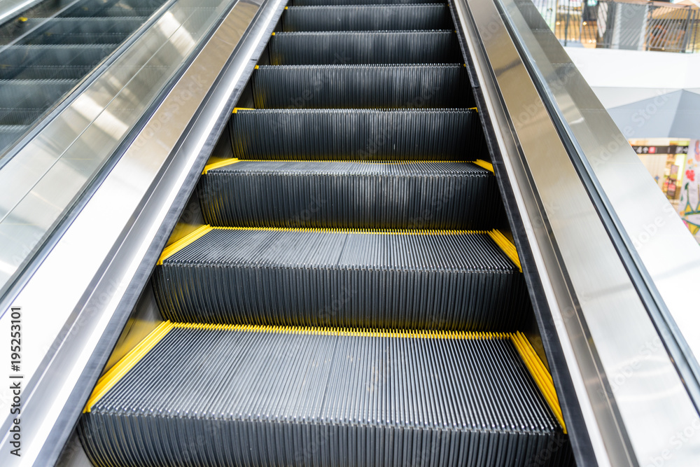 Close up escalator with yellow line in shopping mall. Close up escalator with yellow line in shopping mall.