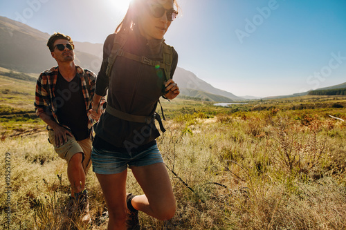 Young couple hiking together through extreme terrain photo