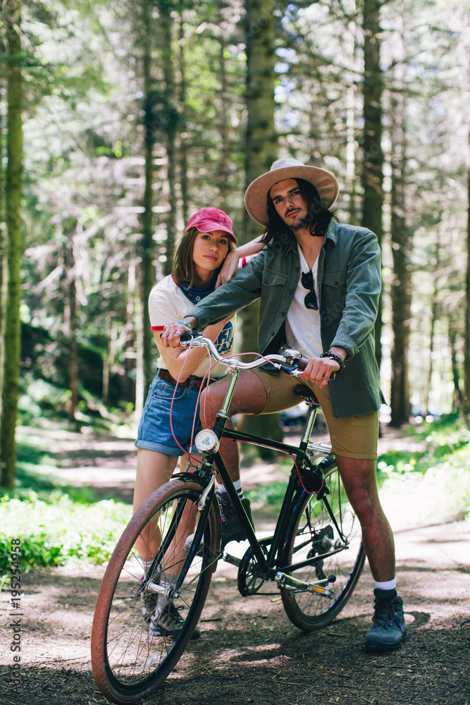 Young couple riding a bike on the woods. Young couple riding a bike on the woods.