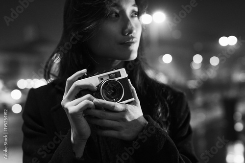 Female Asian photographer in the city at night photo