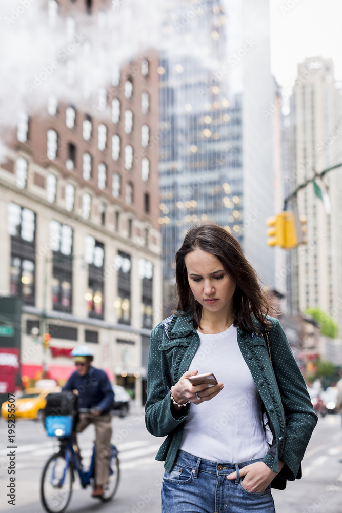 Woman using mobile phone while walking on New York streets Woman using mobile phone while walking on New York streets