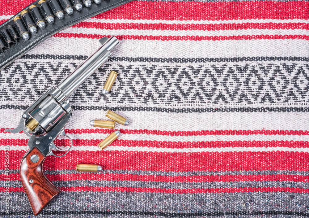Single Action Revolver reloading bullets with gun belt on mexican blanket  Stock-foto | Adobe Stock