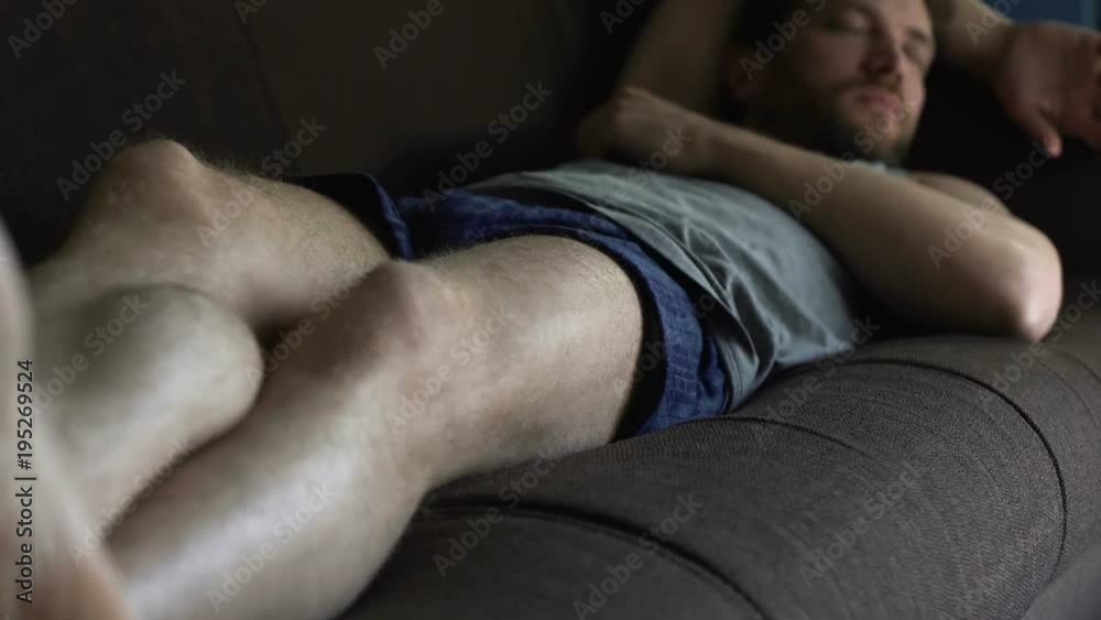 Untidy drunk male in boxers sleeping on sofa, relax time of single man at home