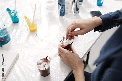 Young female artist painting abstract acrylic canvas in studio