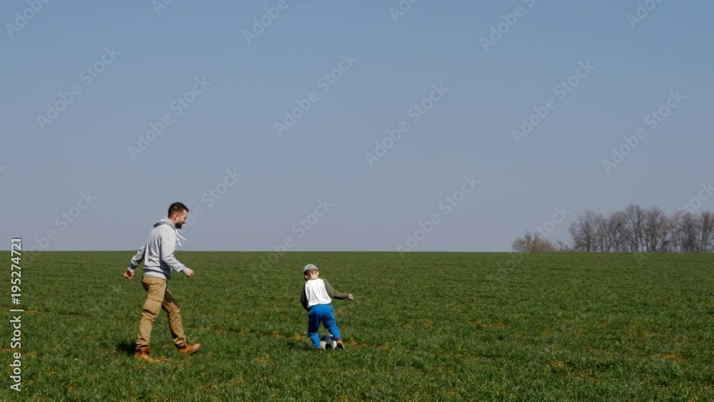 Bearded father and son practicing football, panning Bearded father and son practicing football, panning