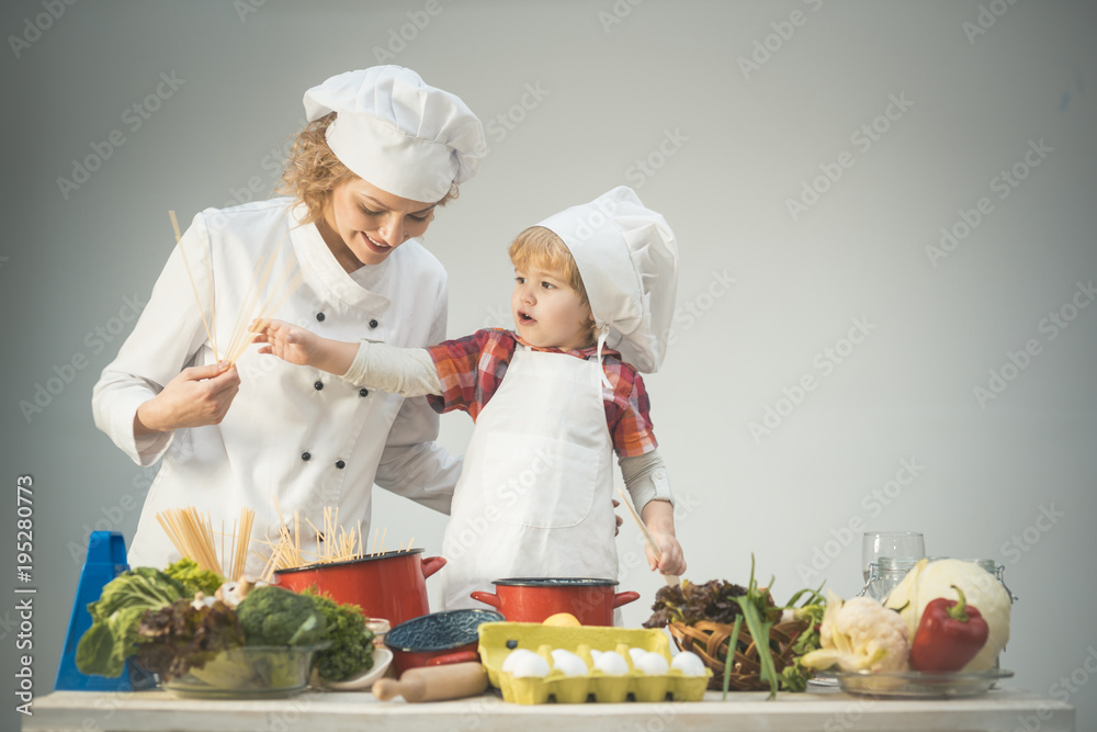 Mom and kid with smiling face cooking spaghetti together. Mom and kid with smiling face cooking spaghetti together.