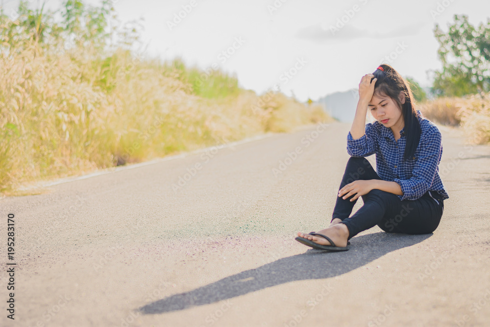 Portrait  beautiful Asian woman in depression and frustration sitting on road