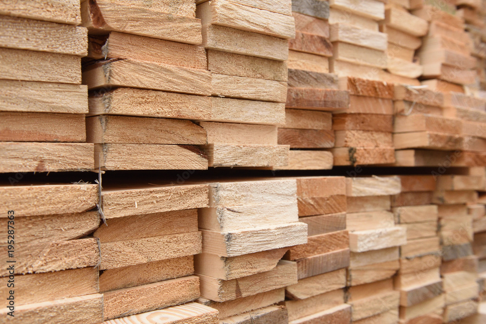 Texture of folded wooden planks in a warehouse with a forest. View from the end Texture of folded wooden planks in a warehouse with a forest. View from the end