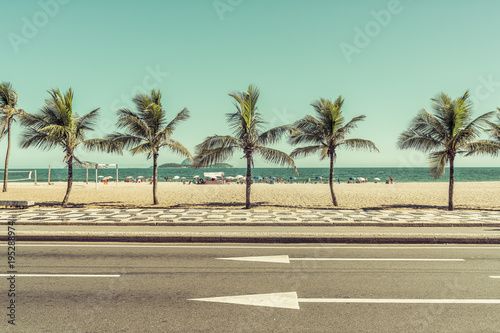 City Beach with palms behind the asphalt road. Ipanema Beach, Rio de Janeiro, Brazil