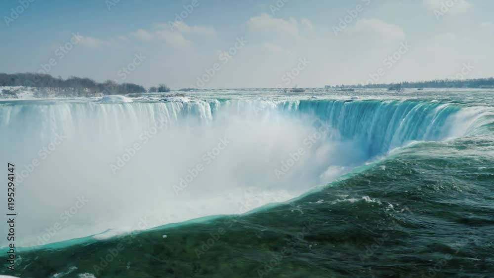 Epic scene of Niagara Falls. A waterfall in the shape of a horseshoe, ice floes float along the water. Tourism in winter concept Epic scene of Niagara Falls. A waterfall in the shape of a horseshoe, ice floes float along the water. Tourism in winter concept