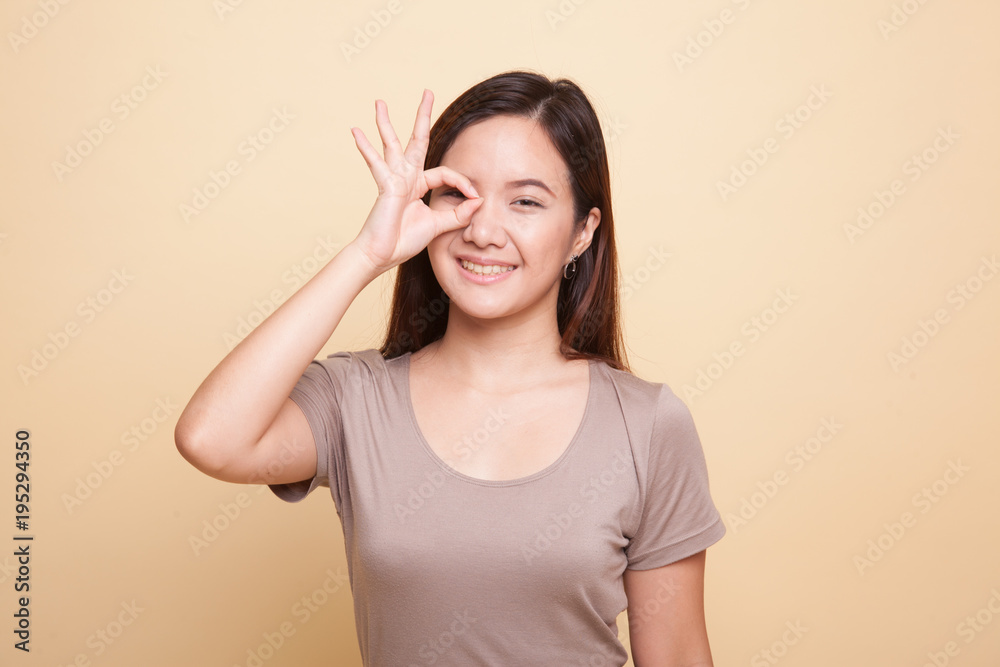 Beautiful young Asian woman show OK sign over her eye. Beautiful young Asian woman show OK sign over her eye.