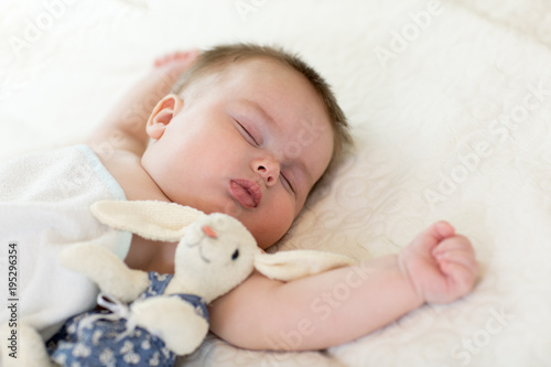 Portrait of cute baby sleeping on bedspread, close up view