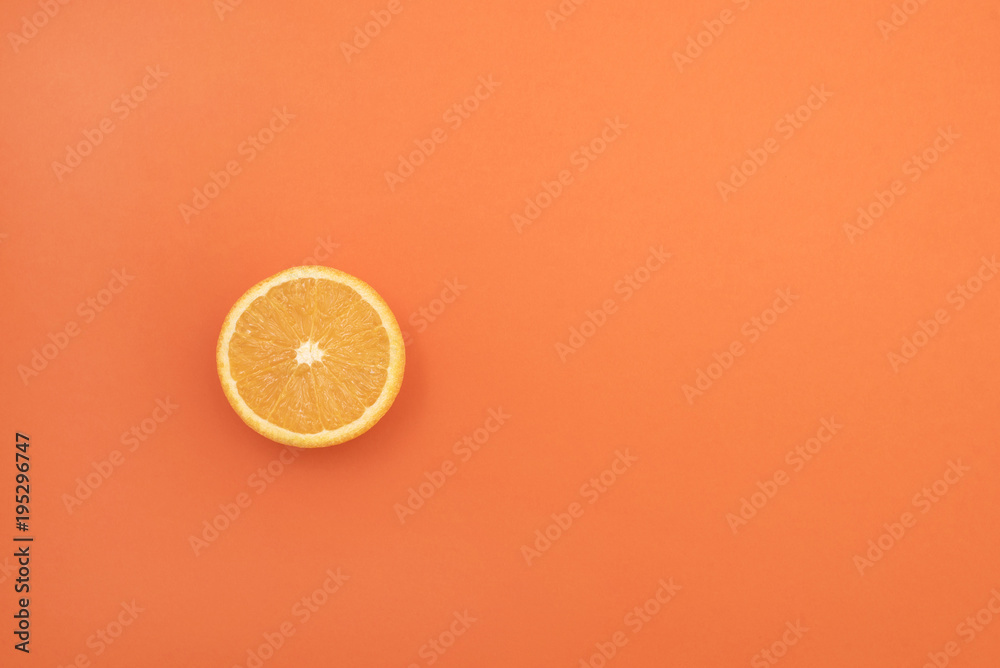 Fototapeta One orange cut in half on an orange background