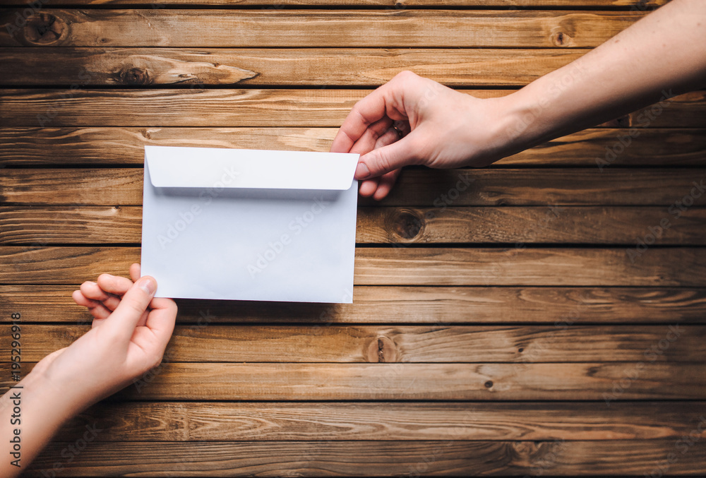 White envelope in the hands of two people. Online donation. The concept of writing. The Internet. White envelope in the hands of two people. Online donation. The concept of writing. The Internet.