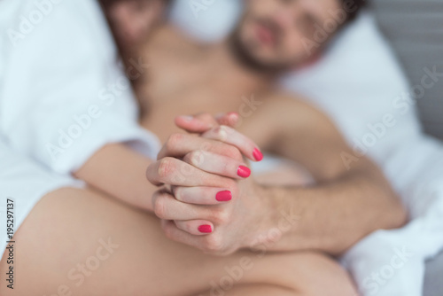 selective focus of couple holding hands together