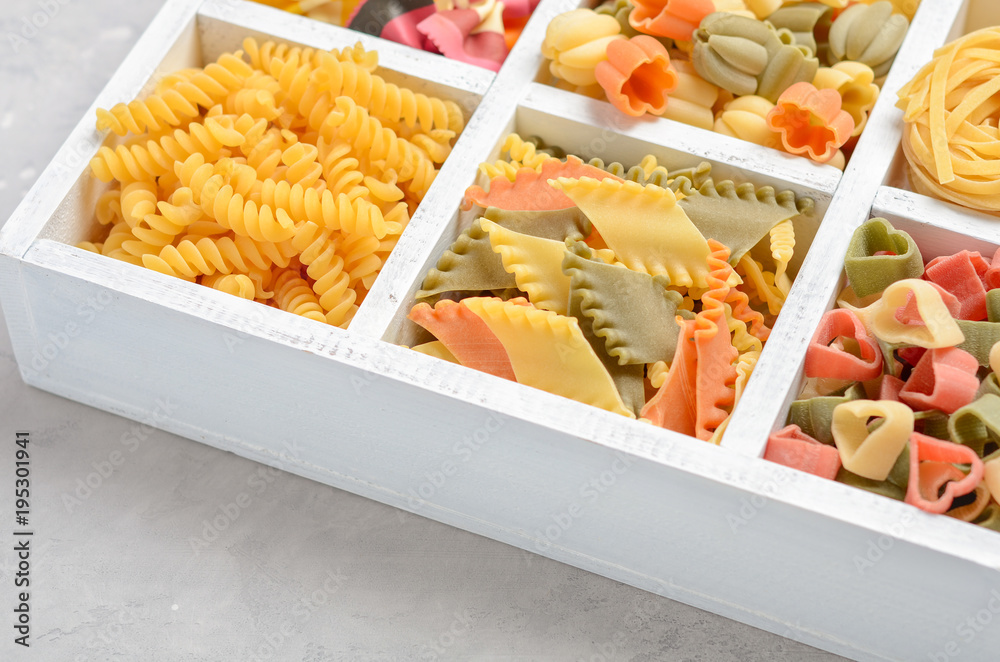 Variety of types and shapes of raw Italian pasta. Selective focus.