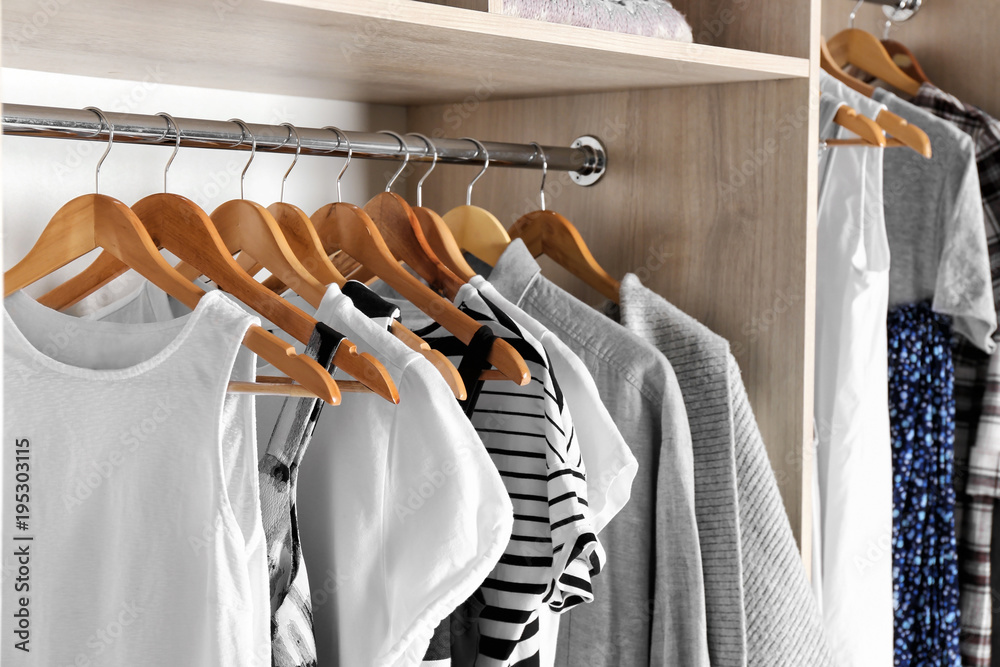Hangers with different clothes in wardrobe closet - obrazy, fototapety, plakaty 