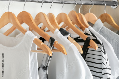 Hangers with different clothes in wardrobe closet photo