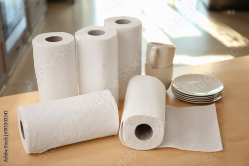 Rolls of paper towels and dishware on table indoors