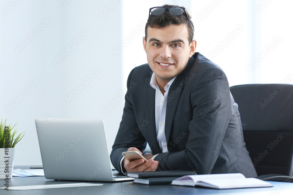 Young man in office wear working with laptop at table Young man in office wear working with laptop at table