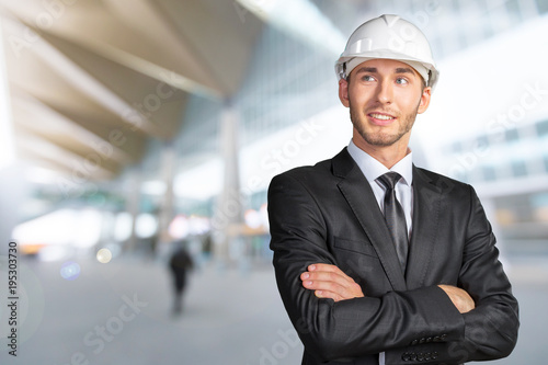 Young handsome engineer in white hardhat