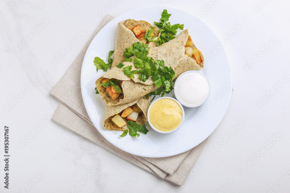 Vegetarian masala dosa with potato, chutney and sambar sauces. Vegetarian masala dosa with potato, chutney and sambar sauces.