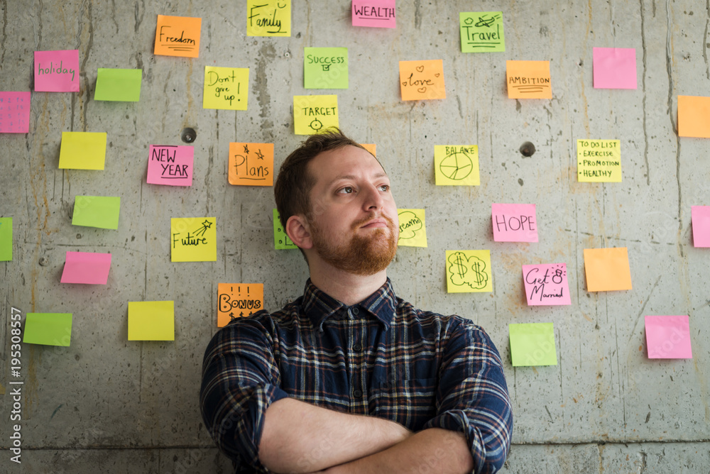 Happy man crossed arm with sticky notes chart on cement wall. Entrepreneur concept. Happy man crossed arm with sticky notes chart on cement wall. Entrepreneur concept.