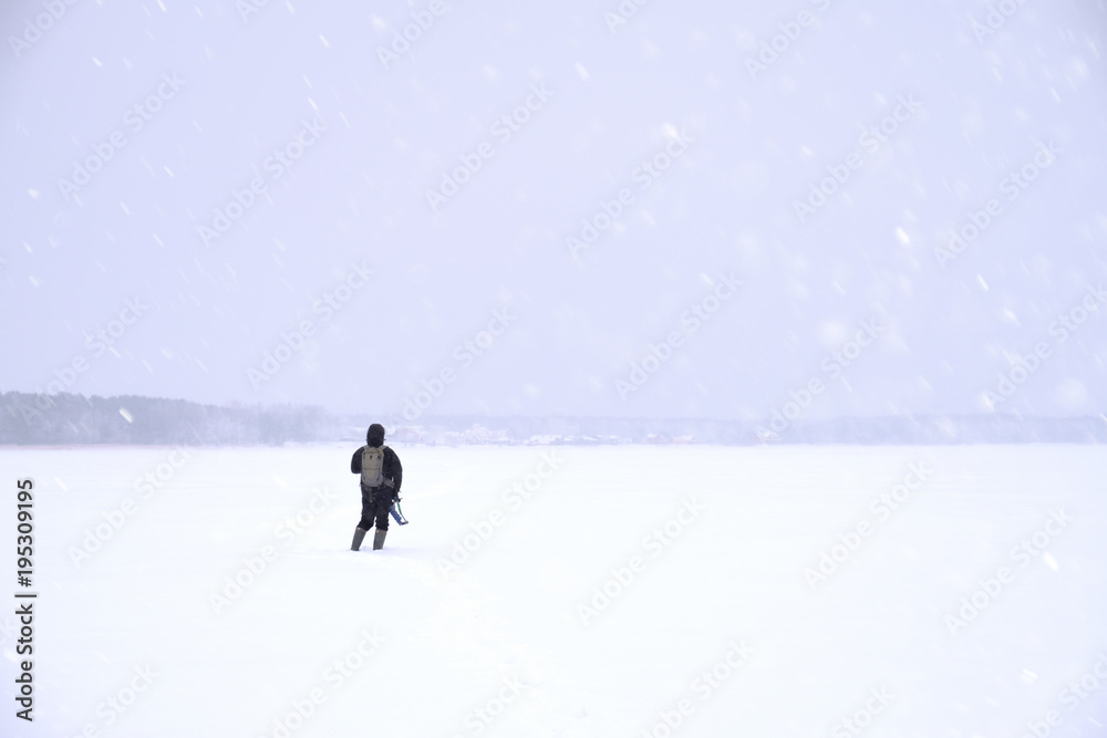 Fisherman out into the snowy expanse of the lake. Winter fishing.