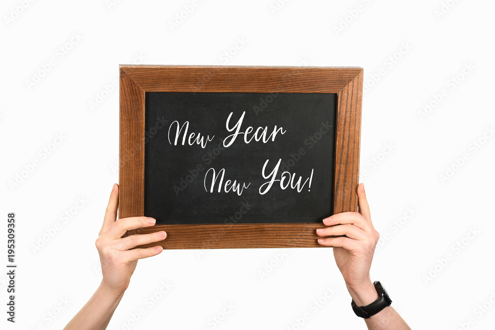Cropped view of woman hands holding board with lettering new year new you isolated on white Cropped view of woman hands holding board with lettering new year new you isolated on white