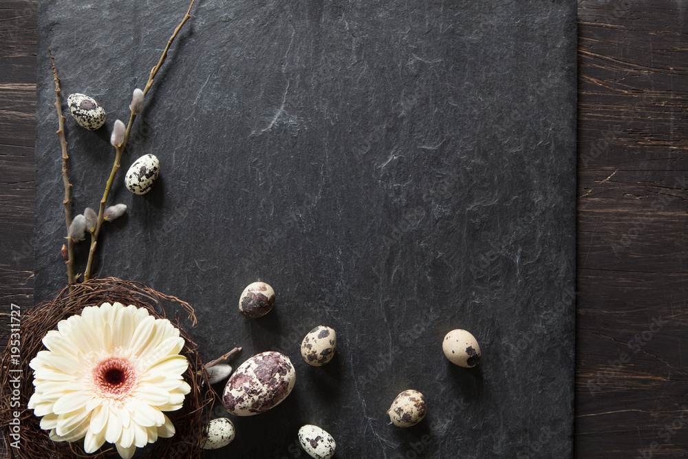Fototapeta premium Easter background with dark stone, gerbera flower in a wreath, fluffy willow and natural eggs