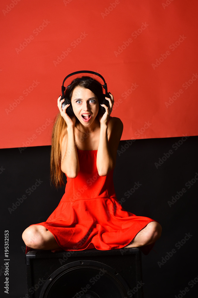 Naklejka premium Girl with loose hair wears headphones. Singer with surprised face