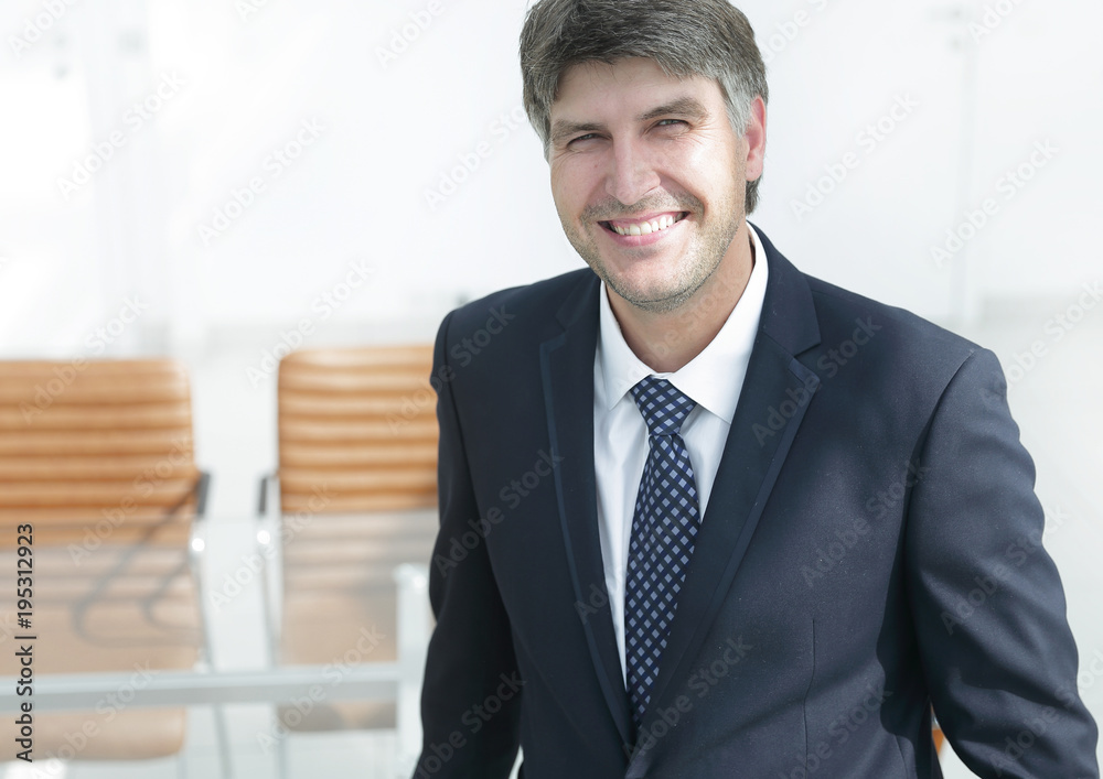 successful businessman standing by the desk. successful businessman standing by the desk.