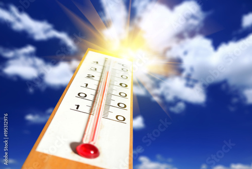 Thermometer with sunshine over blue sky